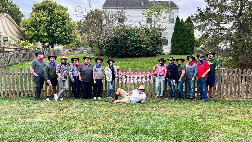 Il team di wenglor USA si presenta in tenuta da cowboy davanti a una staccionata western durante un barbecue estivo in stile Wild West.