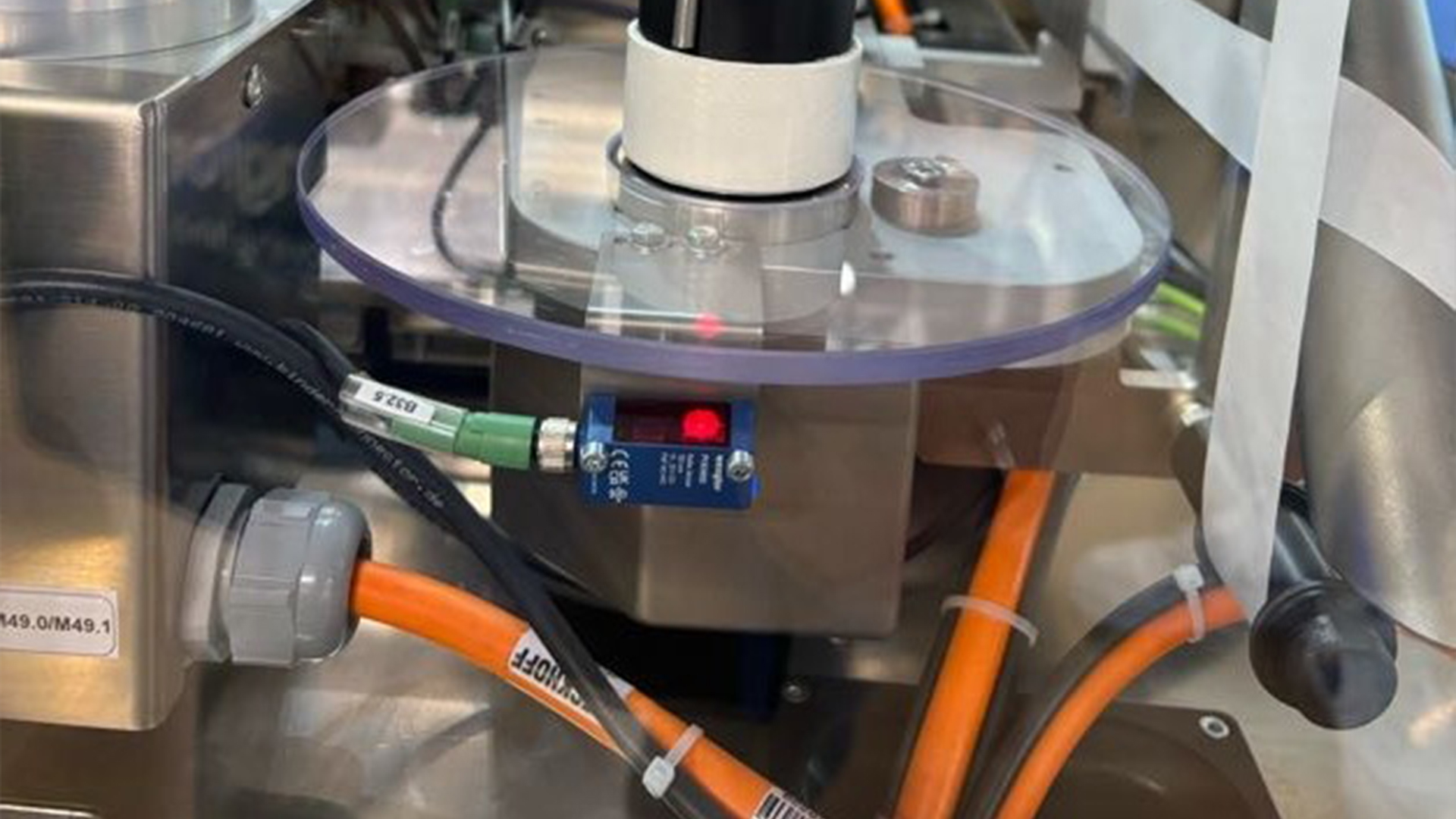 เซ็นเซอร์สะท้อนกลับใต้แท่นหมุนโปร่งใสทำหน้าที่ตรวจสอบสถานีการติดฉลาก